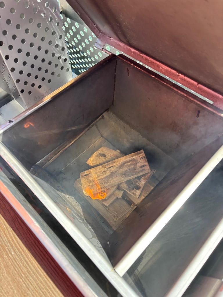 Kindling smouldering inside an open hot tub stove firebox